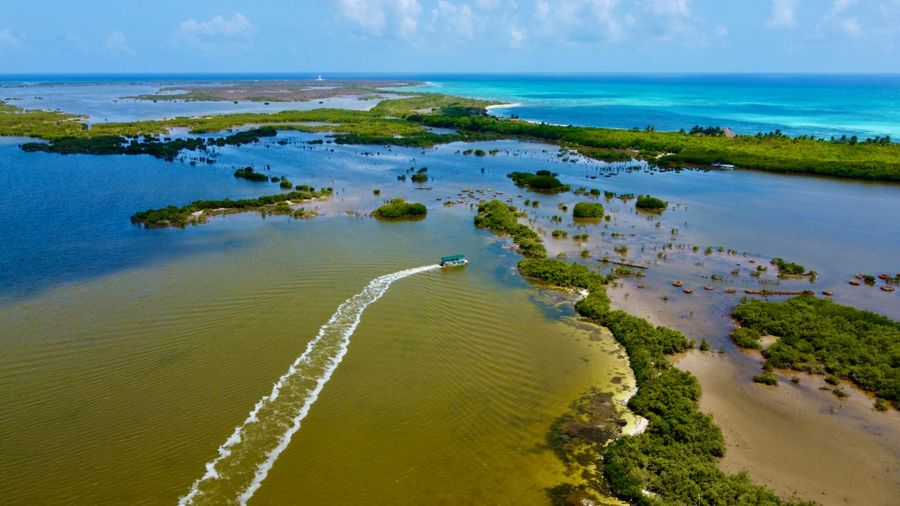 Vista aérea del sistema lagunar de Punta Sur, con manglares, una embarcación y el Caribe al fondo